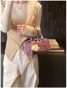 Sac bowling violet en simili daim avec pendentif chiot dans un décor minimaliste chic