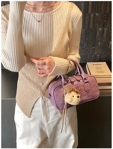Gros plan sur le sac bowling rétro violet en cuir mat avec un charmant pendentif ours