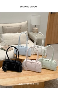 Five minimalist baguette bags in various colors displayed on a cozy wooden table set
