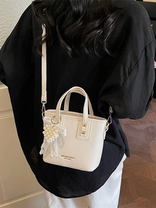 Chic off-white bucket bag with lychee grain leather, pearl charm and gold hardware