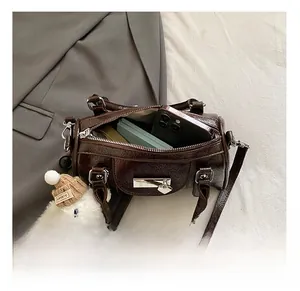 Top view of deep brown glossy cylinder bag showing interior capacity and cute dog charm