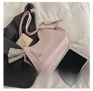 Détail d'un sac cabas rose en cuir synthétique avec zip à gland et petit pochon