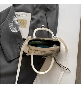 Top down view of white faux leather tote showing spacious interior for phone and power bank