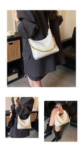 Close-up of beige dumpling bag featuring embossed leather texture and chunky gold chain