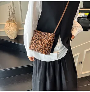 Vue détaillée d'un sac seau léopard avec une bandoulière en cuir marron