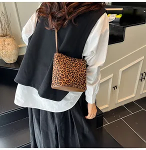 Détail du sac seau à motif léopard avec base marron et fine bandoulière