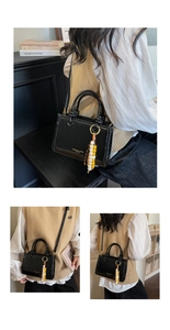 Detail of black glossy leather crossbody bucket bag with bohemian beaded charm decoration