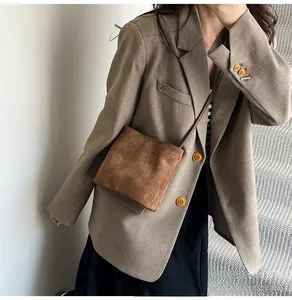 Sac à bandoulière en daim marron mat avec une tenue au style minimaliste moderne