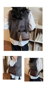 Detail of dark brown leather bucket bag featuring unique wooden bead fringe and gold text