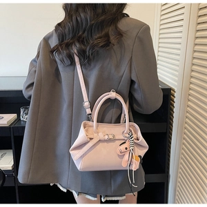 Pink minimalist tote bag with adjustable shoulder strap and cute dog charm shown on model