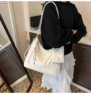 Détail du sac cabas en similicuir blanc avec cordon latéral et petite pochette jointe