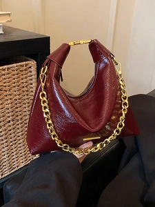 Fashionable burgundy glossy shoulder bag with chunky gold chain and metallic clasp