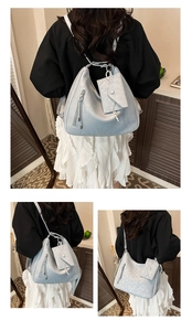 Détail du sac à dos Hobo bleu clair en cuir souple avec fermeture éclair et petite pochette