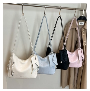 Détail de quatre sacs Hobo chics en ivoire, bleu, noir et rose avec petites pochettes