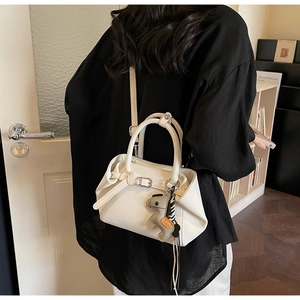 Detailed back view of a white leather tote bag featuring a cute grey donkey charm