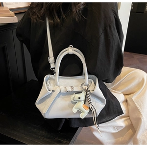 Light blue minimalist tote bag detail with decorative buckle and contrast horse charm