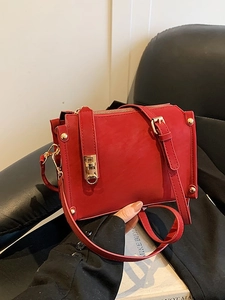 Chic red faux leather crossbody bag with gold hardware and accordion pleat design