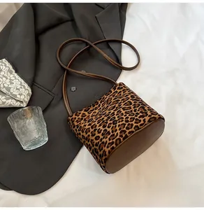 Détail du sac à main léopard avec base en cuir marron et fine bandoulière réglable