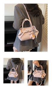 Detail of light pink baguette bag featuring decorative buckle and leather horse charm