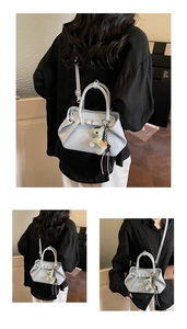 Detailed views of a blue-grey pleated tote bag with a cute dinosaur charm accessory