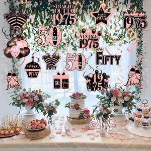 50th birthday party decorations with 1975 rose gold hanging swirls on dessert table