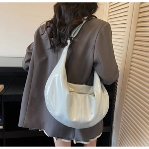 Détail d'un sac à bandoulière croissant vert menthe avec finition vernie brillante