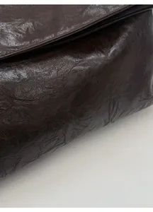 Detailed view of dark brown faux leather tote with textured finish and Korean script