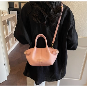 Pink lychee textured bucket bag with gold hardware and removable shoulder strap