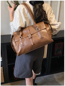 Détail du sac cabas vintage en cuir marron avec fines bandoulières et boucles en métal