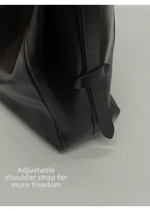 Close-up of adjustable strap and fine stitching on dark brown leather tote bag