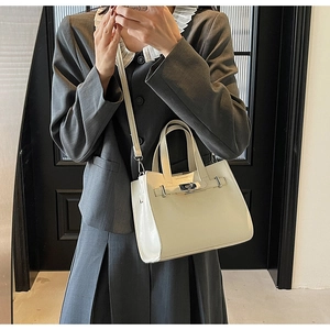 Dettaglio della borsa tote in pelle verniciata bianca con chiusura a scatto in metallo