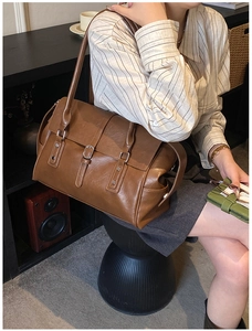 Détail d'un sac cabas vintage en cuir marron avec boucles argentées et fines lanières