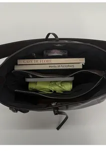 Detailed interior of large brown leather tote bag with compartments and zipper pockets