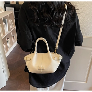 Close-up of cream lychee texture handbag with gold hardware and brand leather logo