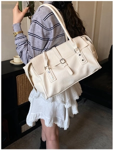 Vue latérale du grand sac cabas en cuir crème avec boucle métallique et rabat