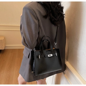 Dettaglio della borsa tote nera elegante con chiusura in metallo e fodera marrone interna