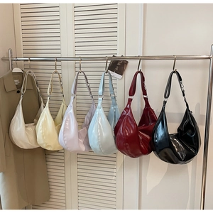 Hobo bags in multiple colors displayed on metal rack featuring glossy PU leather material