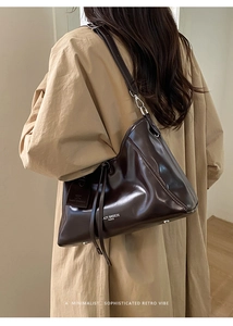 Detail of dark brown leather tote bag featuring Lazy Breeze Paris branding and tag
