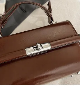 Detailed close-up of dark brown leather texture with silver metal twist-lock buckle