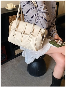 Détail d'un grand sac cabas crème avec doubles lanières à boucles et ferrures argentées