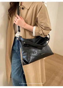 Detail of black vintage shoulder bag featuring textured faux leather and wide strap