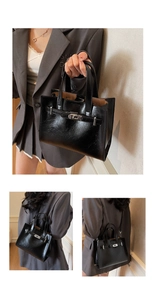 Détail du sac à main en cuir verni noir avec fermoir argenté et bandoulière réglable