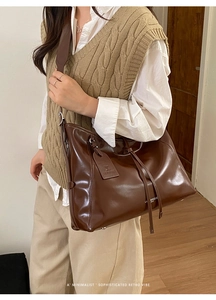 Detail of vintage brown leather tote bag with LA BREEZE PARIS text and leather tag