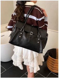 Grand sac cabas vintage noir porté par un mannequin dans un cadre intérieur chaleureux