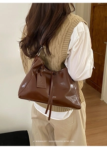 Detail of vintage dark brown tote bag showing smooth leather texture and shoulder strap