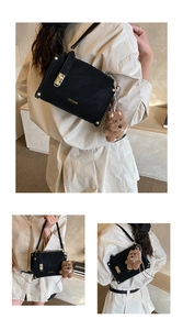 Close-up of black retro square bag with golden twist lock and plush bear charm
