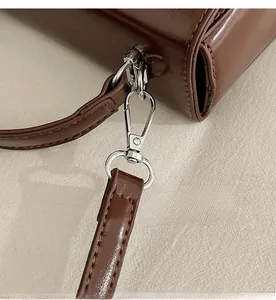 Macro detail of durable silver metal hook and dark brown leather strap stitching