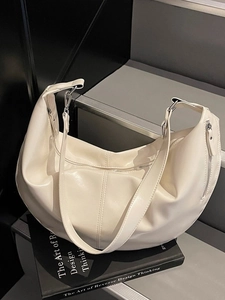 Grand sac hobo crème en similicuir souple avec détails argentés sur fond sombre