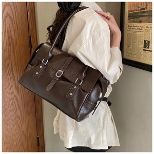 Détail d'un sac cabas vintage marron foncé avec lanières à boucles décoratives