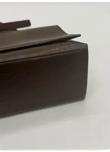 Detail shot of the wide base design on a dark coffee leather tote for a structured shape